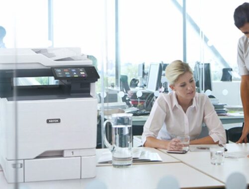 Due donne al lavoro in un ufficio accanto a una stampante multifunzione a colori Xerox® VersaLink® C625